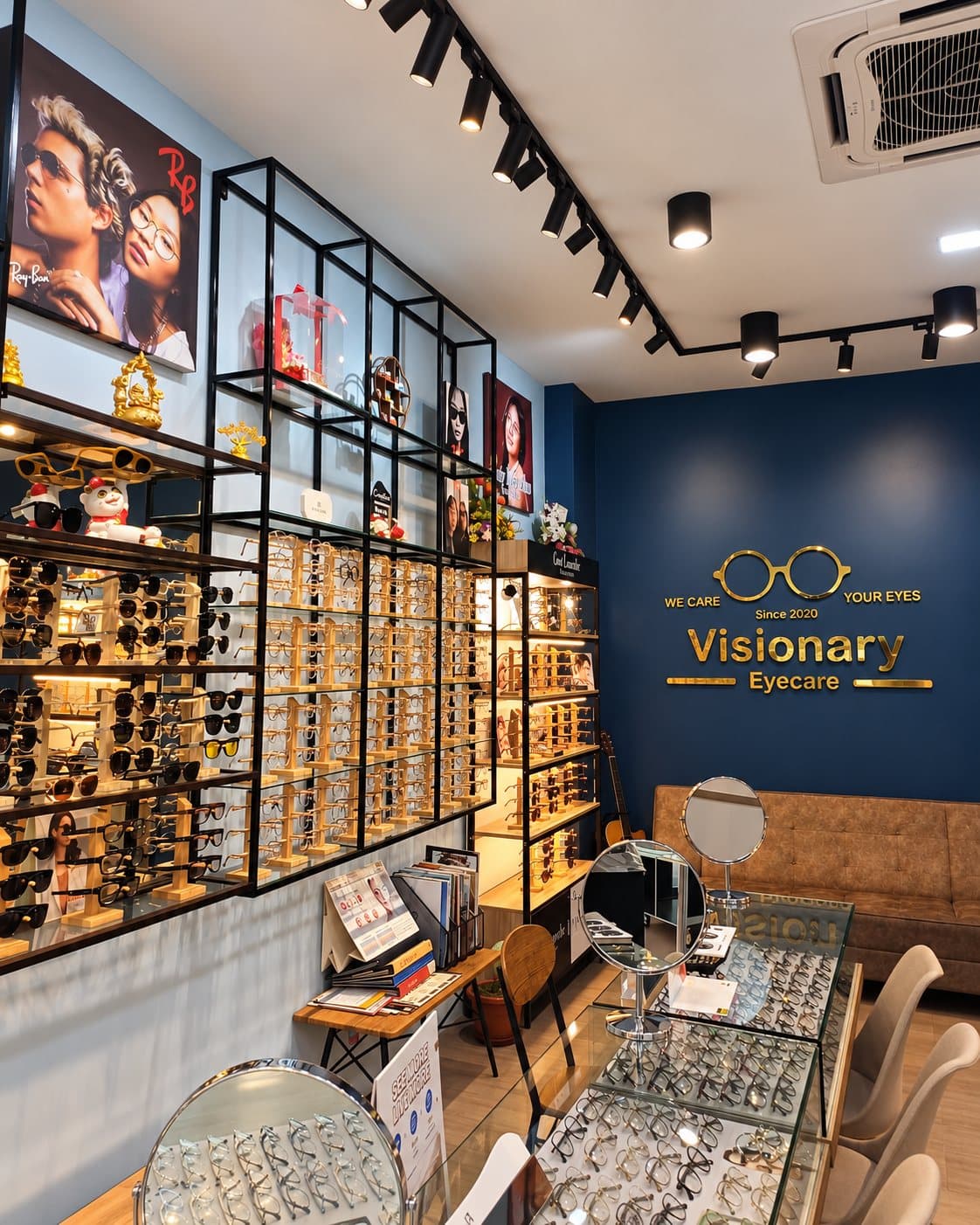 Inside the Visionary Eyecare store at OUG Parklane, with frame displays and the gold logo on the blue wall